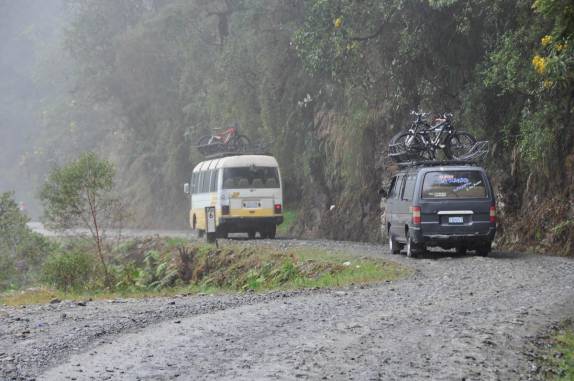 Carros de apoio à ciclistas descem a Carretera de la Muerte, estrada que liga La Paz  à Coroico, na Bolívia